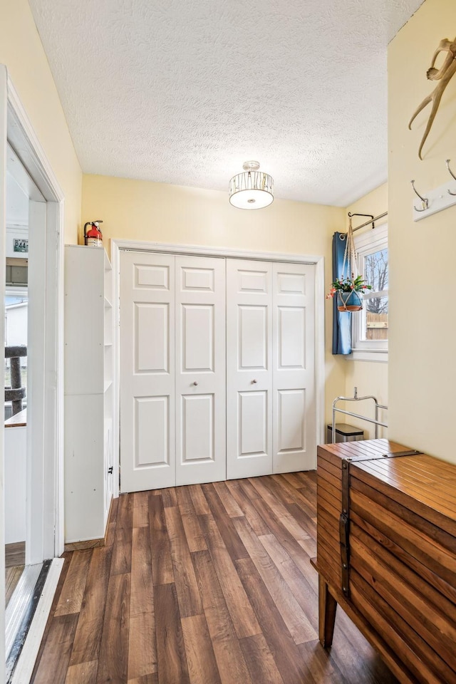 unfurnished bedroom featuring a closet, dark hardwood / wood-style floors, and a textured ceiling