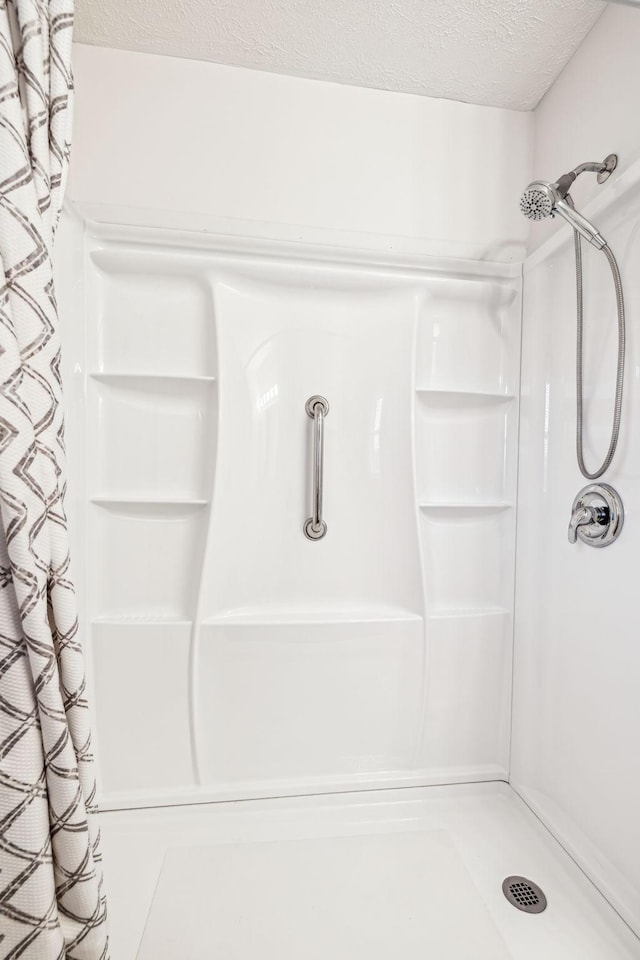 bathroom featuring curtained shower and a textured ceiling