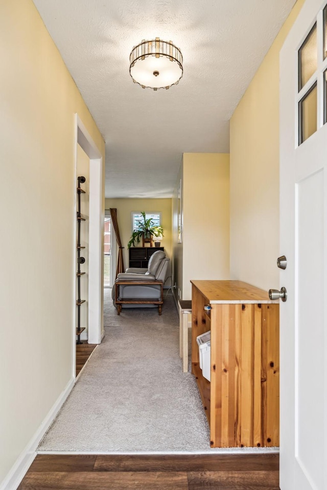 hall with wood-type flooring and a textured ceiling