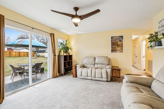 carpeted living room with ceiling fan