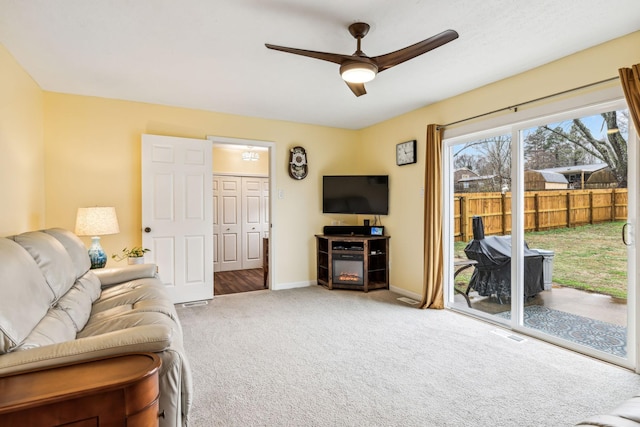 carpeted living room with ceiling fan