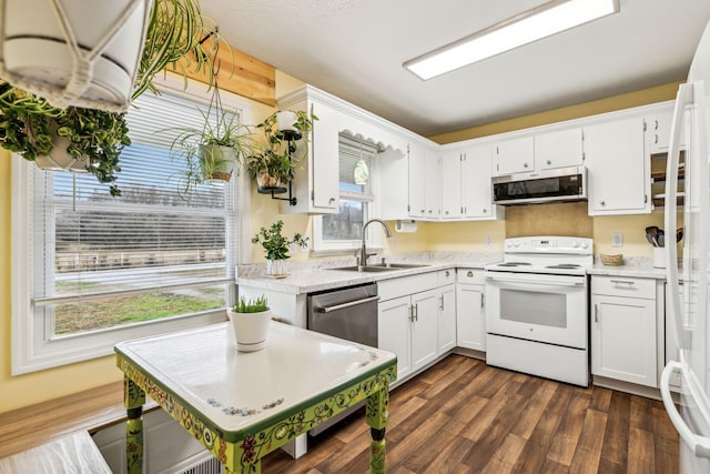 kitchen with dark wood-type flooring, appliances with stainless steel finishes, sink, and white cabinets