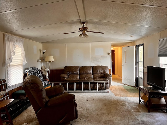 living room featuring ceiling fan and vaulted ceiling with beams