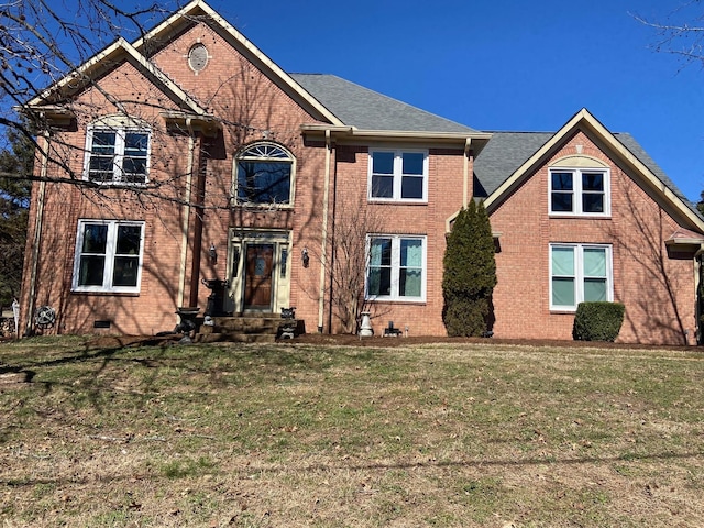 view of front of property with a shingled roof, crawl space, brick siding, and a front lawn