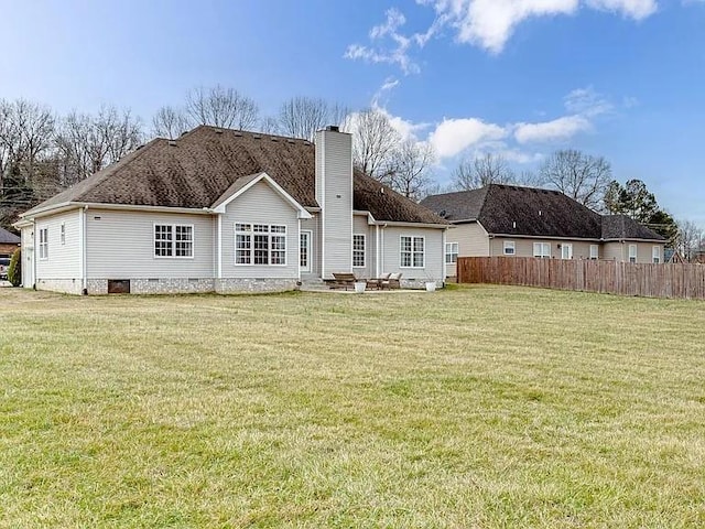 rear view of house featuring a lawn