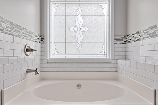 bathroom featuring a healthy amount of sunlight and a tub to relax in