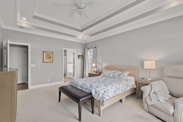 bedroom with light colored carpet, ceiling fan, a raised ceiling, crown molding, and ensuite bath