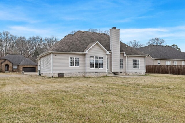 rear view of property featuring a yard and a garage