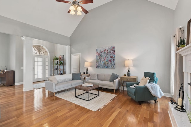 living room with ceiling fan, high vaulted ceiling, light hardwood / wood-style floors, and ornate columns