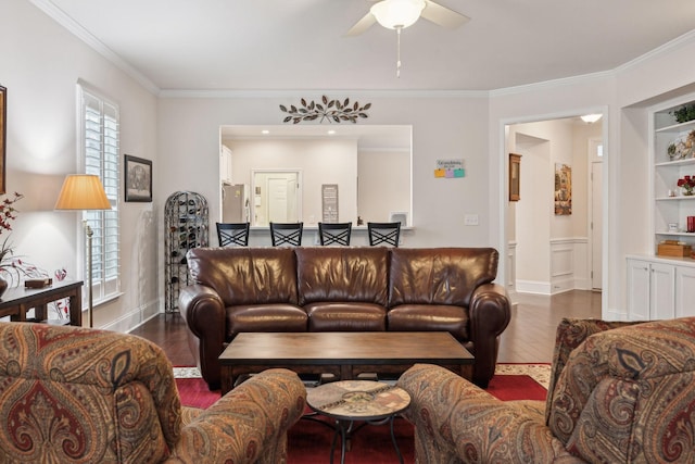 living room featuring crown molding, dark hardwood / wood-style floors, ceiling fan, and built in shelves