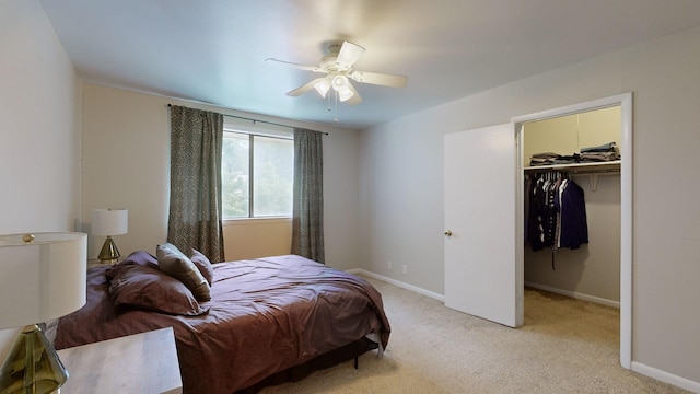 bedroom with baseboards, light colored carpet, ceiling fan, a walk in closet, and a closet