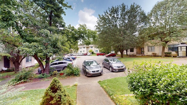 surrounding community with uncovered parking and a yard