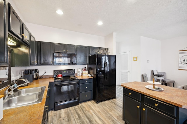 kitchen featuring sink, black appliances, a textured ceiling, wood counters, and light wood-type flooring