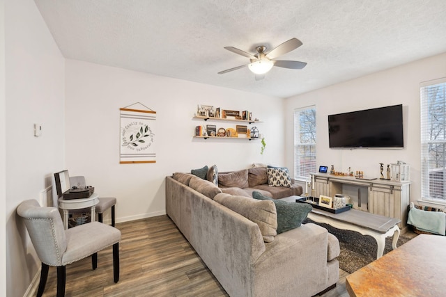 living room with ceiling fan, dark hardwood / wood-style floors, and a textured ceiling