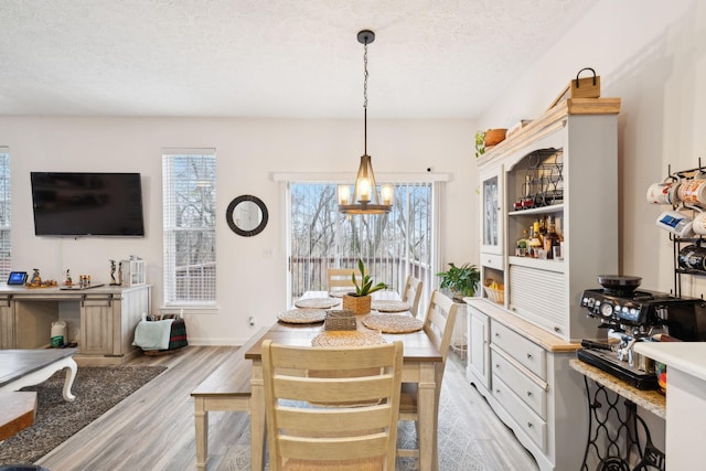 dining room with light hardwood / wood-style floors and a textured ceiling