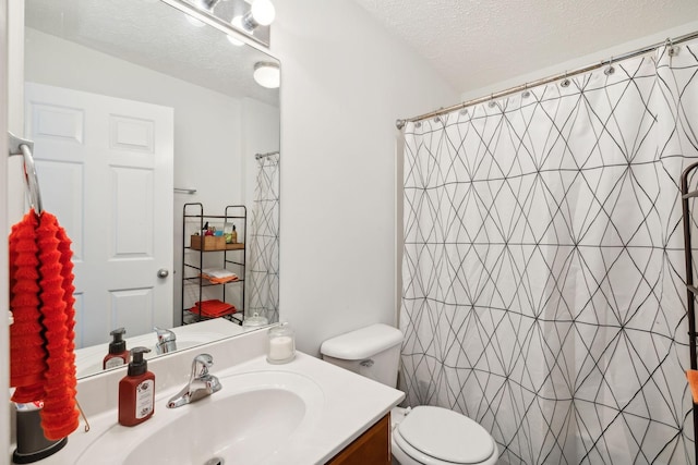 bathroom with vanity, curtained shower, a textured ceiling, and toilet