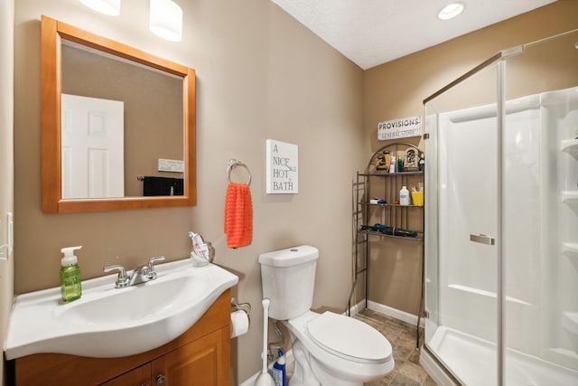 bathroom with vanity, a shower with shower door, and toilet