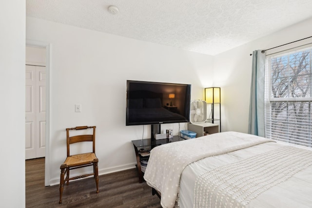 bedroom with dark wood-type flooring and a textured ceiling