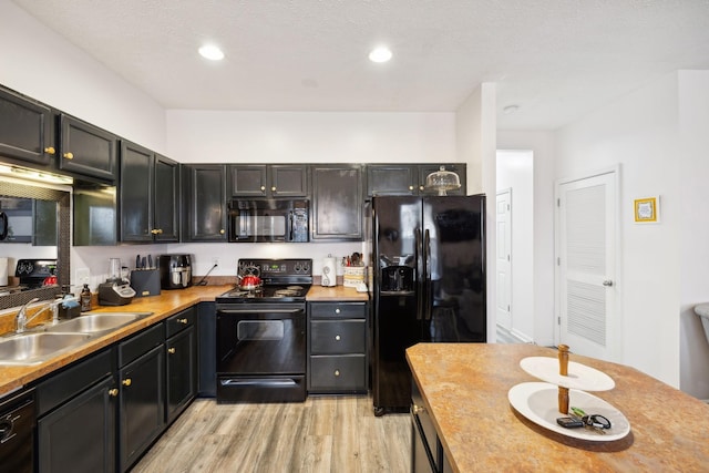 kitchen with sink, black appliances, and light wood-type flooring