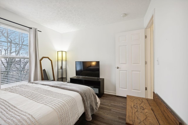 bedroom with dark hardwood / wood-style floors and a textured ceiling