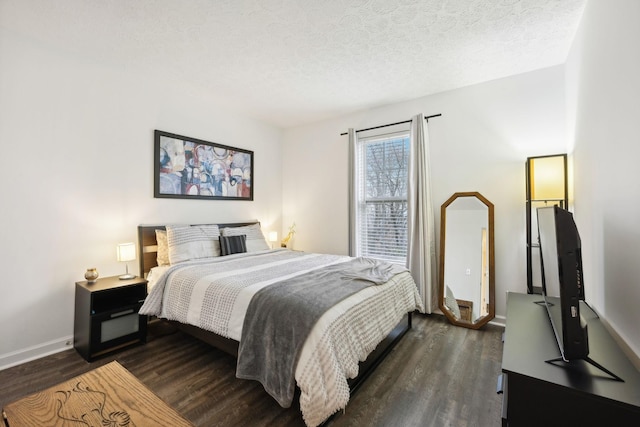 bedroom featuring dark hardwood / wood-style flooring and a textured ceiling