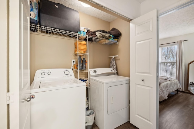 clothes washing area with dark hardwood / wood-style flooring, a textured ceiling, and washer and clothes dryer