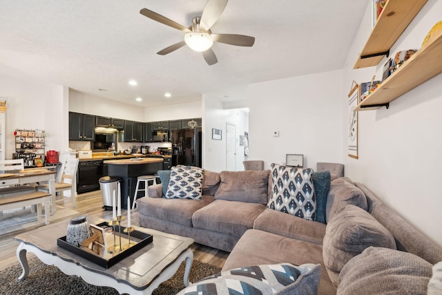 living room featuring ceiling fan and light wood-type flooring