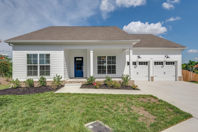 view of front of property with a garage, covered porch, and a front yard