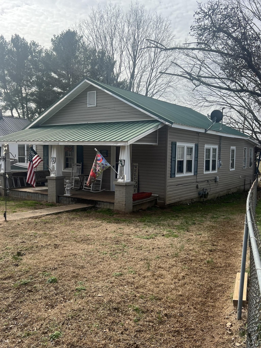 bungalow featuring covered porch and a front lawn