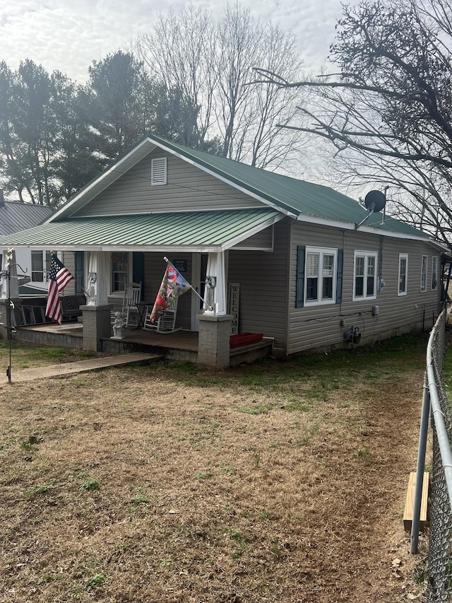 bungalow featuring covered porch and a front lawn