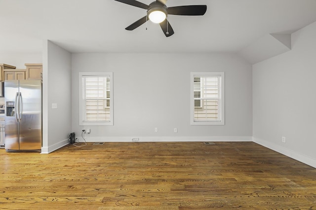 empty room with ceiling fan, dark hardwood / wood-style flooring, and a wealth of natural light