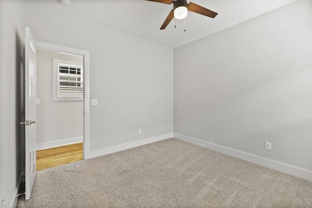 carpeted spare room featuring ceiling fan