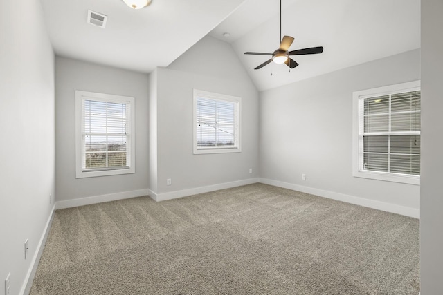 carpeted spare room featuring lofted ceiling, a wealth of natural light, and ceiling fan