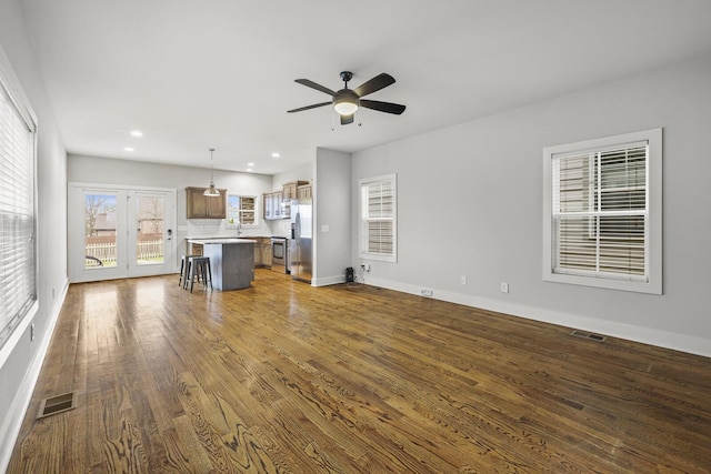 unfurnished living room with ceiling fan, dark hardwood / wood-style flooring, and sink