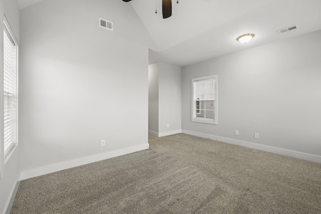 empty room featuring vaulted ceiling, ceiling fan, and carpet flooring