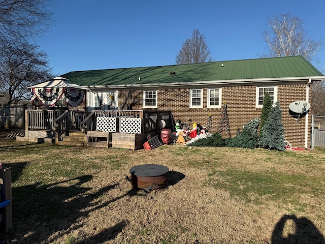 rear view of property with a wooden deck, a gazebo, and a lawn