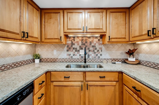 kitchen featuring light stone countertops, sink, stainless steel dishwasher, and backsplash