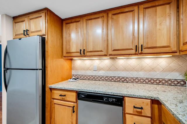 kitchen featuring tasteful backsplash, appliances with stainless steel finishes, and light stone counters