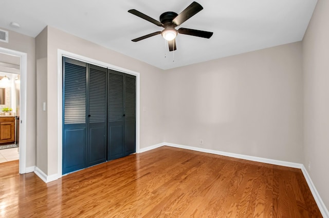 unfurnished bedroom with wood-type flooring, a closet, and ceiling fan