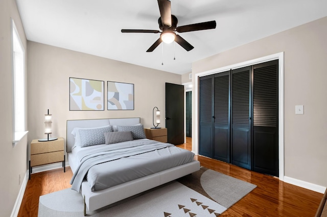 bedroom with ceiling fan, wood-type flooring, and a closet