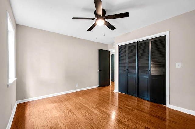 unfurnished bedroom featuring ceiling fan, a closet, and light wood-type flooring