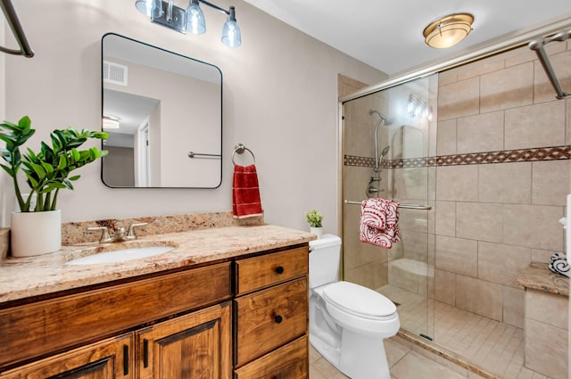 bathroom with tile patterned flooring, vanity, toilet, and walk in shower