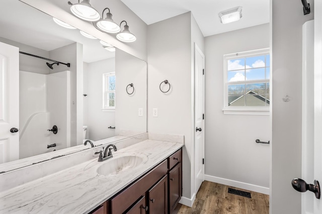 full bathroom with visible vents, vanity, baseboards, and wood finished floors