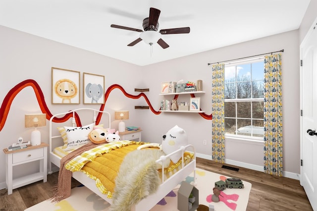 bedroom with visible vents, wood finished floors, a ceiling fan, and baseboards