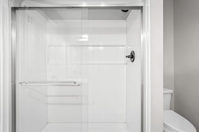 bathroom featuring a stall shower and toilet