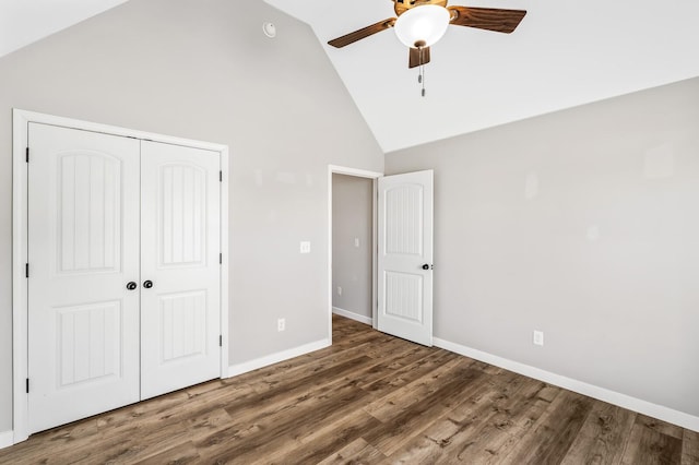 unfurnished bedroom featuring high vaulted ceiling, a ceiling fan, baseboards, a closet, and dark wood-style floors