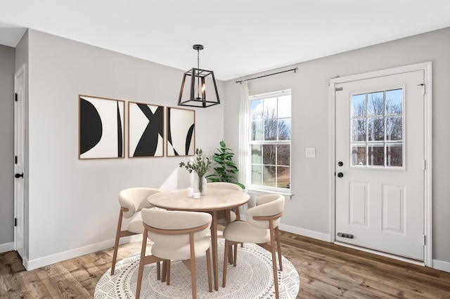 dining area with an inviting chandelier, wood finished floors, and baseboards