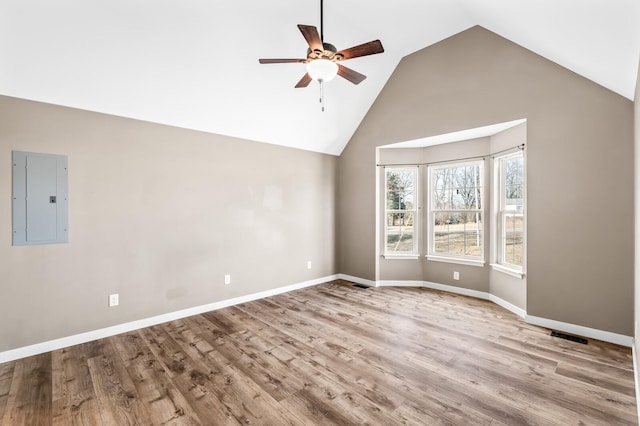 spare room featuring baseboards, light wood finished floors, electric panel, and a ceiling fan