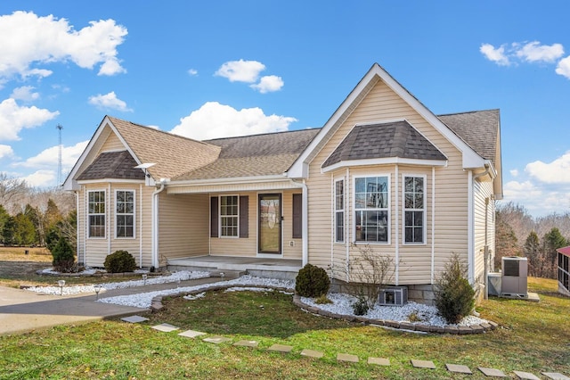 view of front of house featuring covered porch, roof with shingles, a front yard, and cooling unit