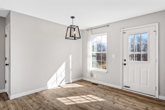 unfurnished dining area with light wood-style floors, visible vents, and baseboards